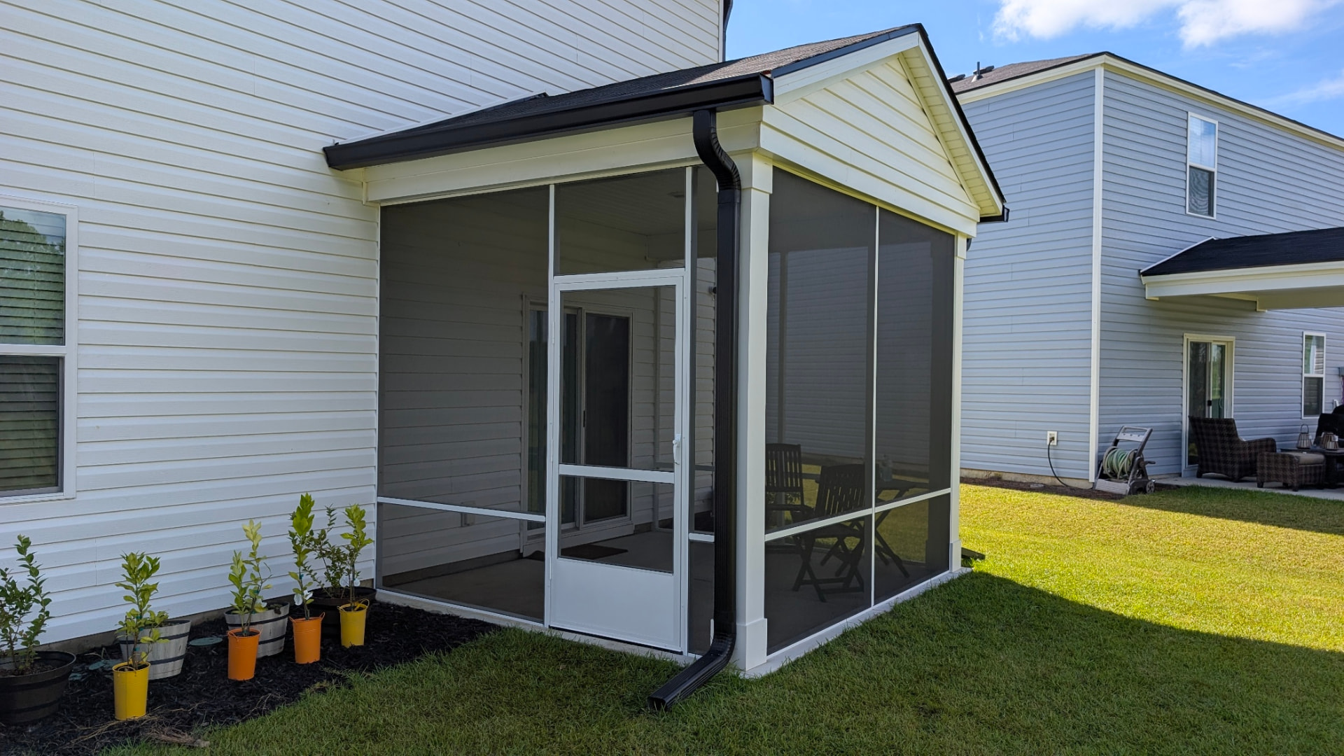 Screened Porch: Gabled screened addition with black gutters in FLORENCE, SC